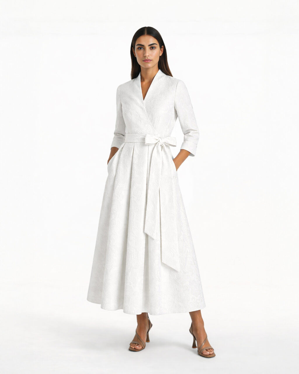 Modelka w białej sukience midi z żakardowej tkaniny, kopertowy dekolt, rękaw 3/4, wiązanie w talii, rozkloszowany dół